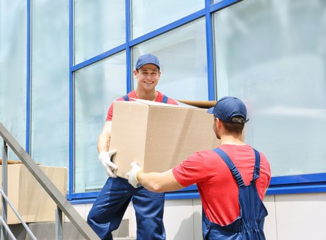 Local office movers handling desks and files in a commercial building
