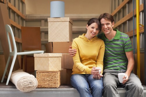 Moving team wearing PPE while carrying furniture carefully